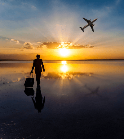 Silhouette of a person at sunset with an airplane in the sky